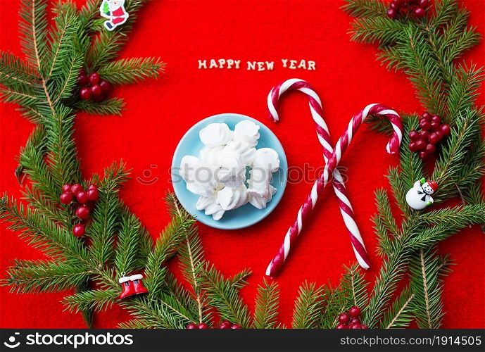 Christmas tree and candy on a red background with the words Happy New Year.. Christmas tree and candy on a red background with the words Happy New Year