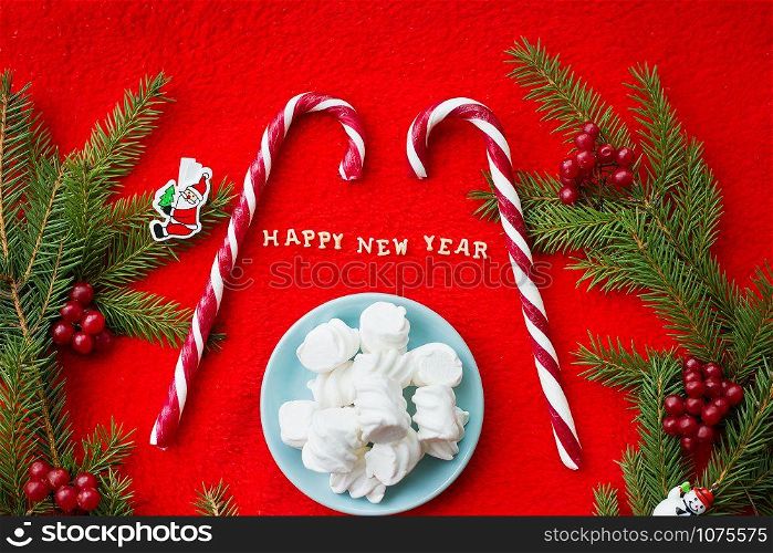 Christmas tree and candy on a red background with the words Happy New Year! Closeup. Christmas tree and candy on a red background with the words Happy New Year Closeup
