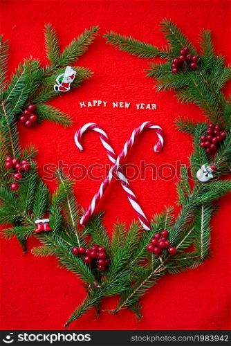 Christmas tree and candy on a red background with the words Happy New Year. Postcard. Christmas tree and candy on a red background with the words Happy New Year