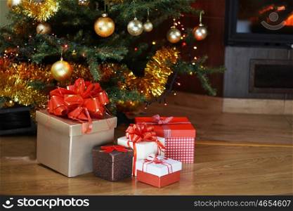 Christmas tree and christmas gift boxes in interior with fireplace