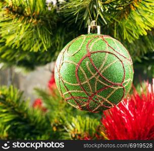 Christmas tree ball on a branch among tinsel