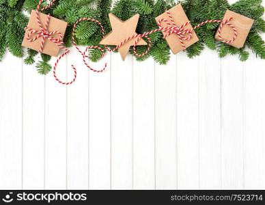 Christmas tree branches and decoration on bright wooden background