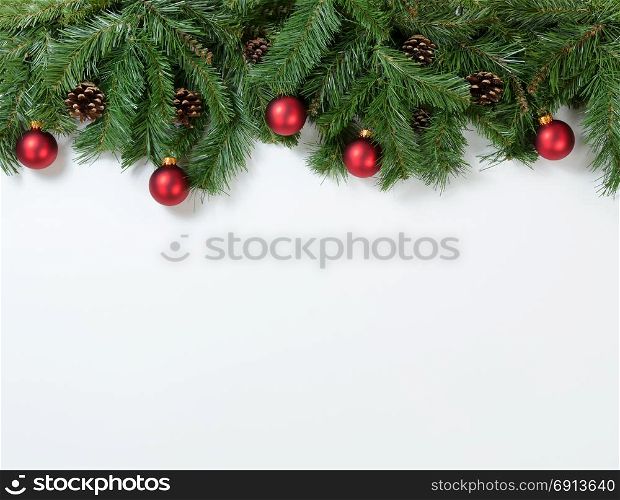 Christmas tree branches and ornaments on white background. Plenty of copy space available.