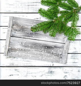 Christmas tree branches on bright wooden background. Evergreen twigs with wood textured desk