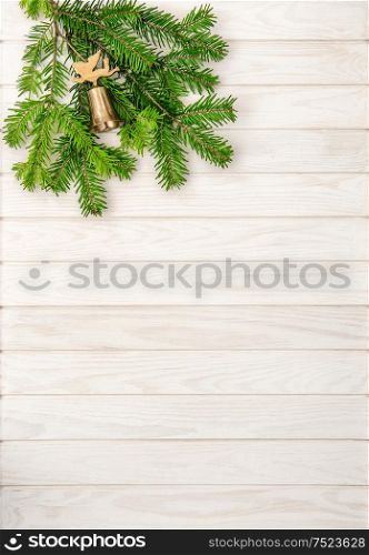 Christmas tree branches on bright wooden background. Undecorated evergreen twigs