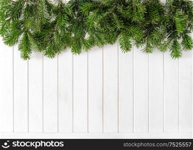 Christmas tree branches on bright wooden texture. Winter holidays background