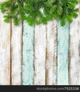 Christmas tree branches on colored rustic wooden background. Winter holidays