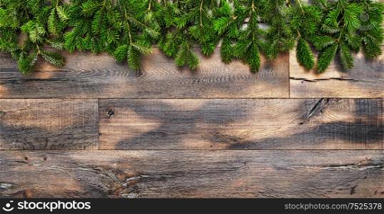 Christmas tree branches on rustic wooden background. Undecorated evergreen twigs