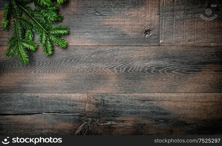 Christmas tree branches on rustic wooden background. Vintage style toned picture