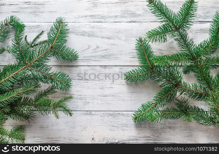 Christmas tree branches on the wooden background