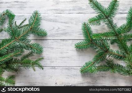 Christmas tree branches on the wooden background