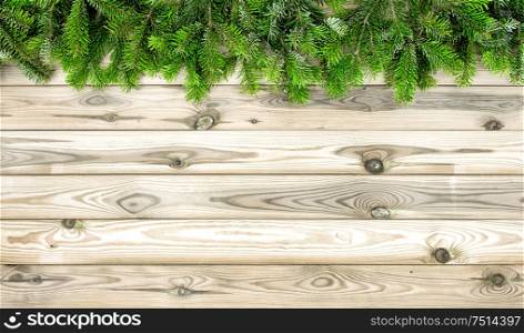 Christmas tree branches on wooden background. Winter holidays