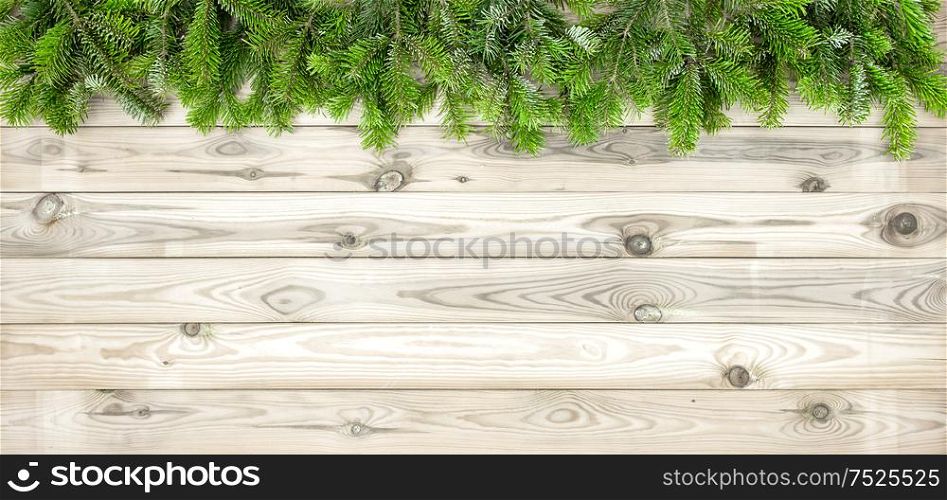 Christmas tree branches on wooden texture. Winter holidays background