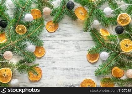 Christmas tree branches with lights on the wooden background