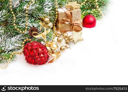 Christmas tree branches with red golden ornaments and gift box on white snow background