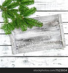 Christmas tree branches with wooden textured desk. Winter holidays background
