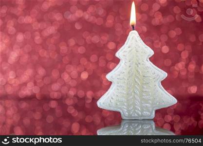 Christmas tree candle light with reflection on red blurred bokeh background.