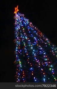 Christmas tree decorated with colorful bright lights cropped diagonally