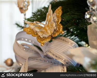 Christmas tree decorated with silver and white ribbons and butterfly ornaments in family home