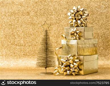 Christmas tree decoration with golden gift boxes. Holidays background
