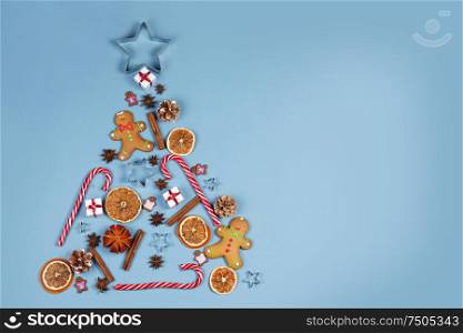 Christmas Tree made of decor on blue paper background. Christmas Holiday Concept. Flat Lay. Christmas Holiday Concept
