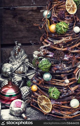 Christmas tree made of wicker,spices and decorations on wooden background