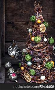 Christmas tree made of wicker,spices and decorations on wooden background
