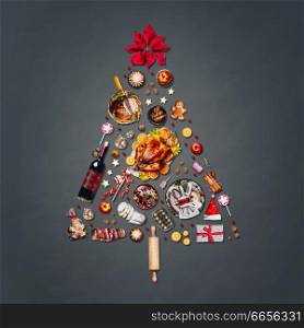 Christmas tree made with various Christmas food: turkey on platter, roasted ham, sweets and candies, cookies , mulled wine, gingerbread man decorated with gift box and poinsettia on gray background