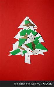 Christmas tree of cut paper on the red background
