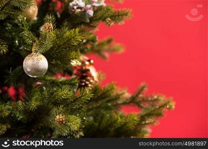 Christmas Tree on red background decorated with golden balls toys and bows