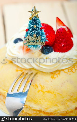 christmas tree on top of a pancake crepe mountain with whipped cream and strawberry