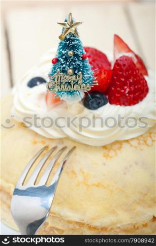 christmas tree on top of a pancake crepe mountain with whipped cream and strawberry