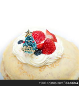 christmas tree on top of a pancake crepe mountain with whipped cream and strawberry