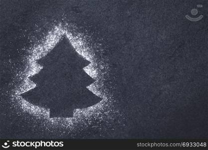 Christmas tree shape formed by powdered sugar on slate, Christmas concept with copy space on the side. Christmas Tree
