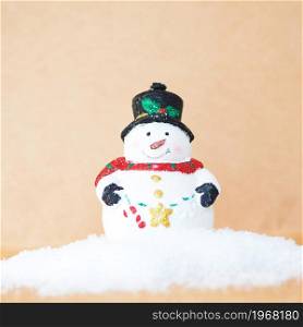 Christmas tree toy cute snowman on a snowdrift on a craft background.