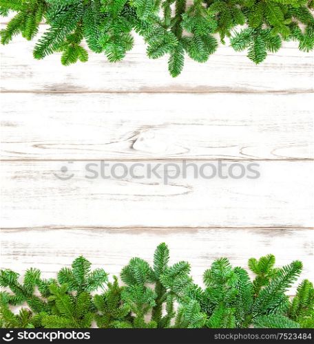 Christmas tree twigs on bright wooden background. Winter holidays decoration