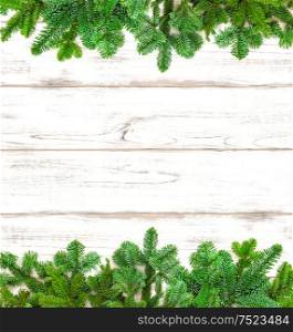 Christmas tree twigs on bright wooden background. Winter holidays decoration