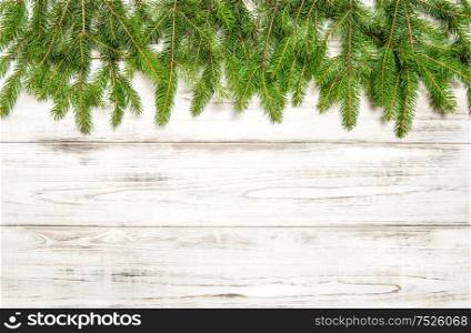 Christmas tree twigs on wooden background. Winter holidays concept
