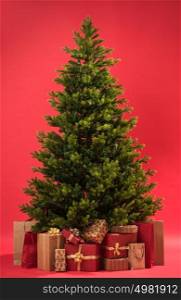 Christmas tree with gifts on red background full length
