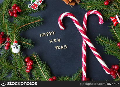 Christmas tree with ornaments and candy on a black background. The inscription Happy New Year.. Christmas tree with ornaments and candy on a black background. The inscription Happy New Year