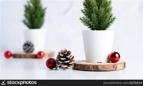 christmas tree with pine cone and decor xmas ball on white table and marble tile wall background.clean minimal simple style.holiday still life