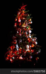 Christmas tree with shiny ornaments isolated on black