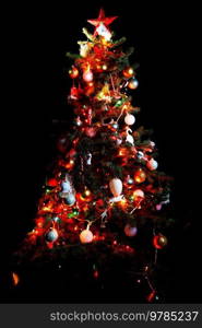 Christmas tree with shiny ornaments isolated on black