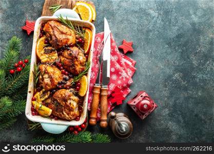 Christmas turkey legs baked with cranberries, orange and rosemary. Delicious festive dish for Christmas time. Top view, christmas food background with space for a text