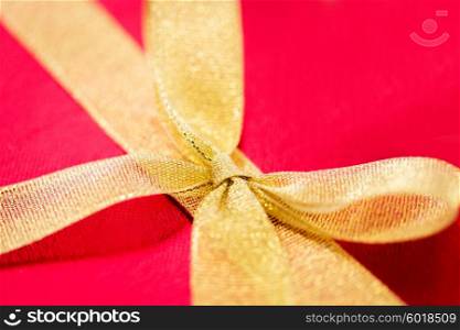 christmas, valentines day and holidays concept - close up of red gift box with golden ribbon bow