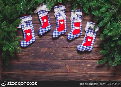 Christmas vintage decor - blue gingham booties on the wooden table with copy space. Christmas vintage decor