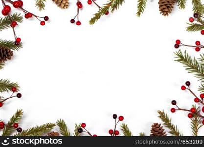 Christmas white blank card with copy space and frame decor of fir tree branch cones red holly berry isolated on white background. Christmas card frame decor on white