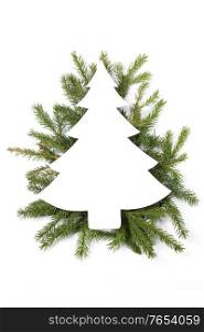 Christmas white fir tree shaped blank card with copy space and decor of fir tree branch isolated on white background. Christmas card and decor on white