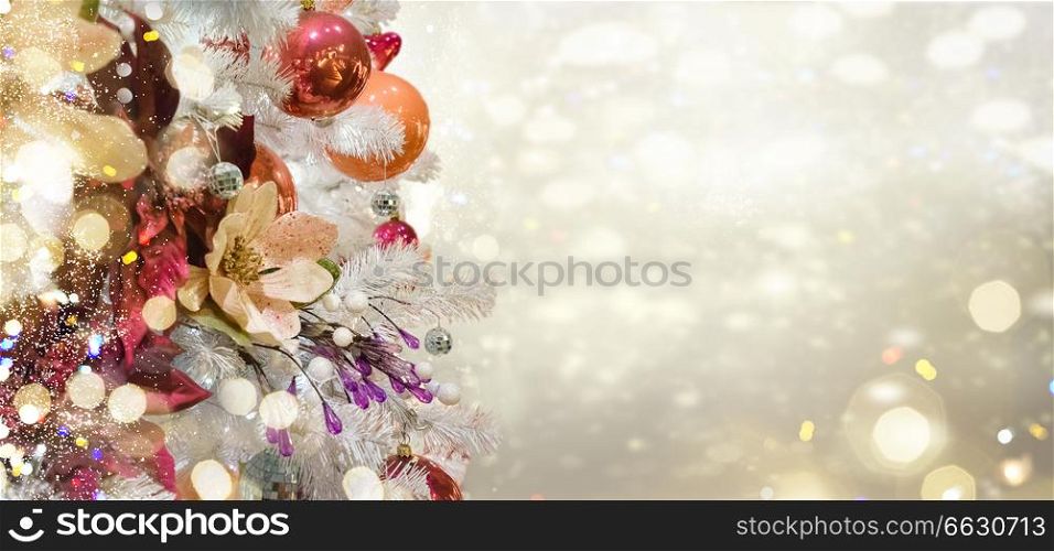 christmas white tree with holiday red and orange decorations and lights with copy space on silver bokeh background. christmas fir tree with decorations