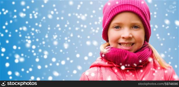 christmas, winter, childhood, and people concept - happy beautiful little girl portrait over snow background